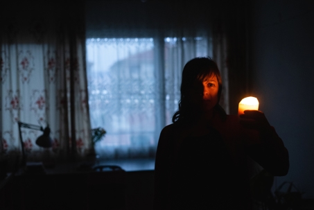 woman holding candle because lights are not working
